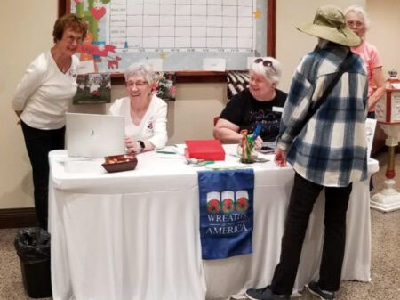 Elaine Cain, Jude Mente, and Judy Lohavani helping community members sponsor 82 wreathsfor veterans' graves through Wreaths Across America.